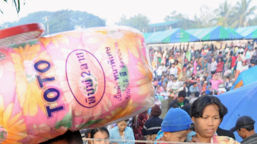 A boy carries a bag as Myanmar refugees arrived in a temporary camp in Thailand