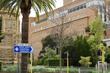 Royal Perth Hospital with a palm tree in the foreground and RPH sign.