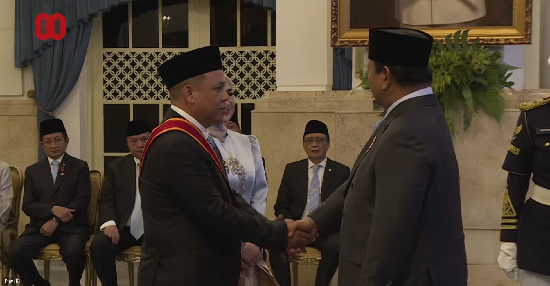 Two men in gray suits and black caps shook hands