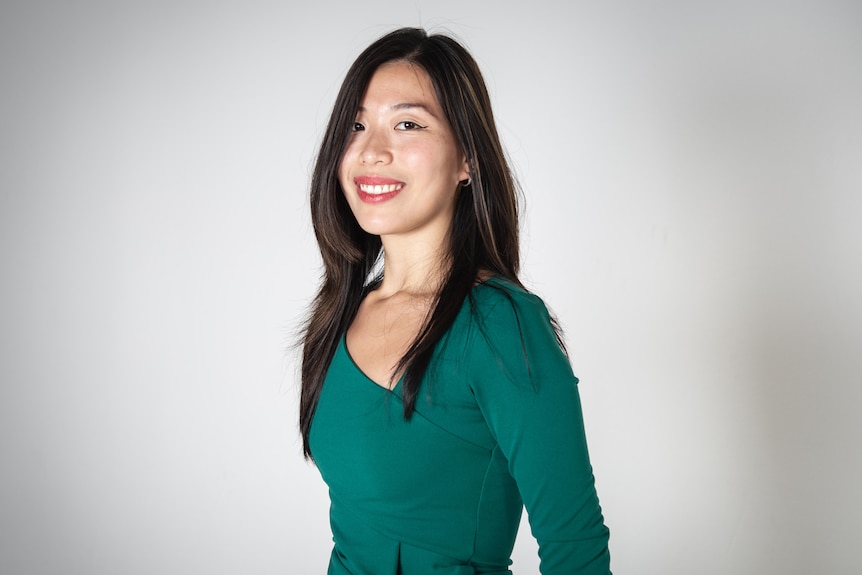 a woman smiling in front of a white background