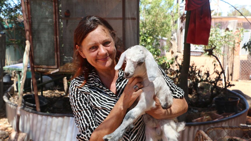 Kye Schaaf with a lamb at the Menindee sanctuary.