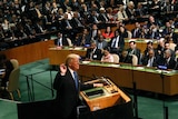 Donald Trump makes his trademark thumb-to-forefinger gesture while addressing a large crowd at the UN.