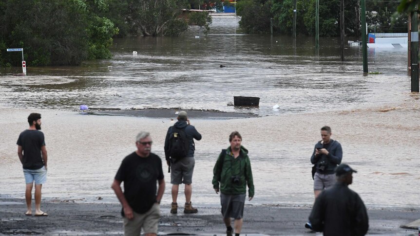 People look at Lismore's flooded CBD after the Wilsons River breached its banks.