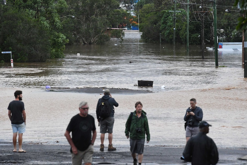 People look at Lismore's flooded CBD after the Wilsons River breached its banks.