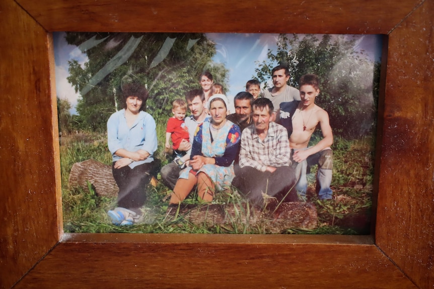 A wooden photo frame with an old family portrait.