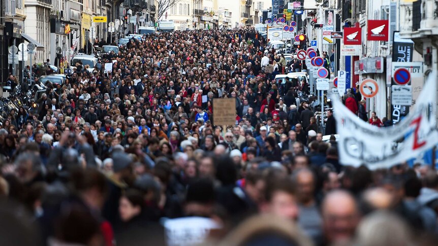 Large crowd of people marching through a street in France