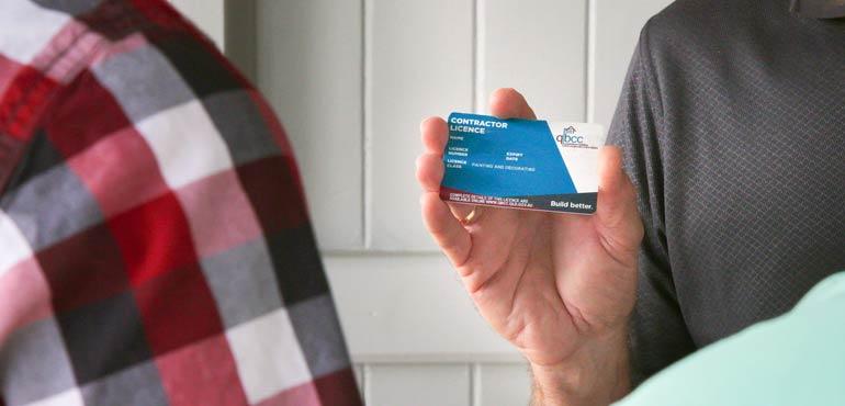 a person showing a QBCC licence to another