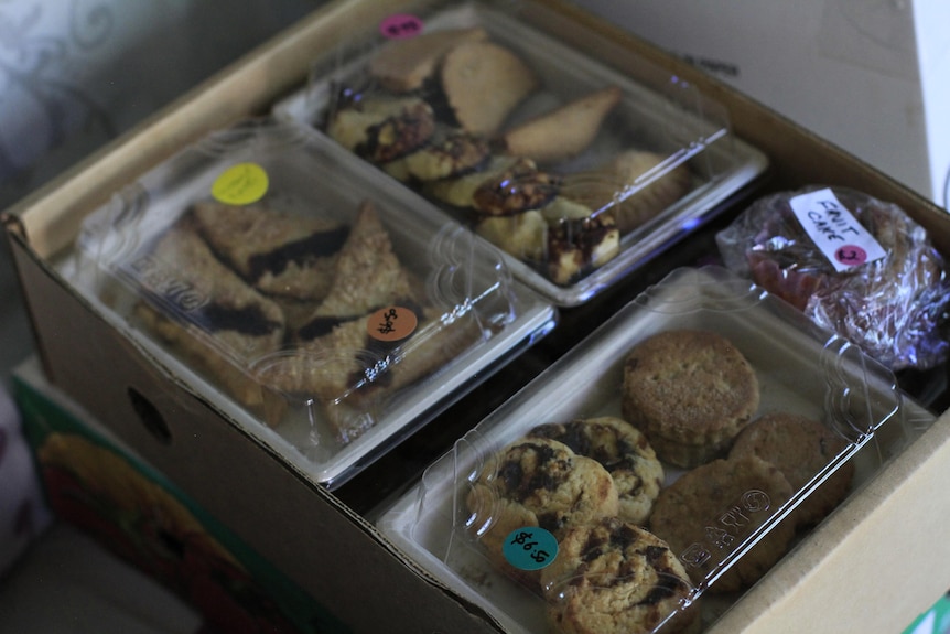 A brown box full of date-based foods like slices, muffins, and biscuits.