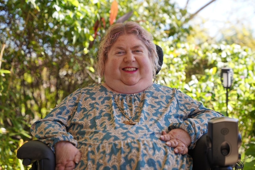 Sharon smiles in a wheelchair.