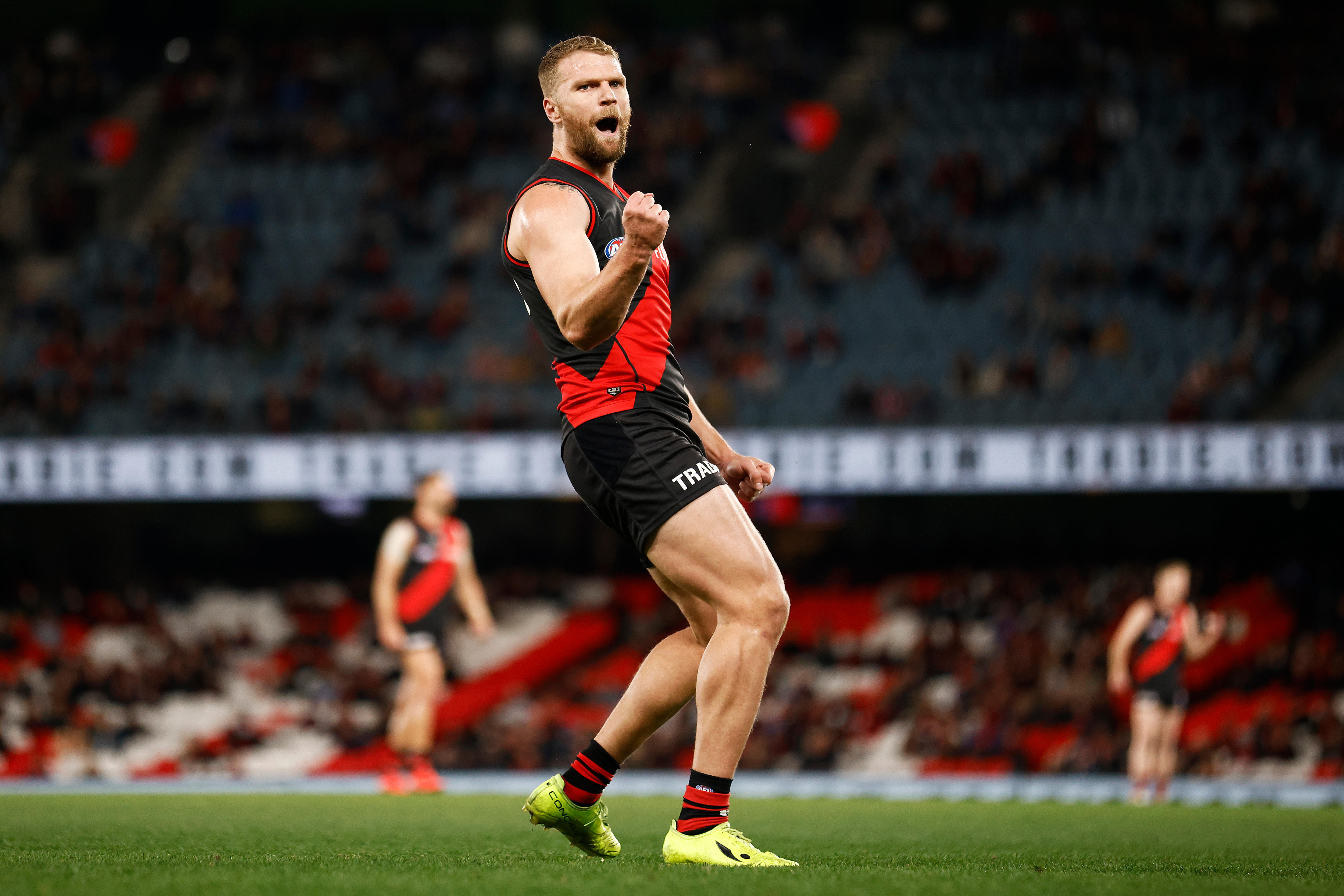 An Essendon AFL player celebrates kicking a goal.
