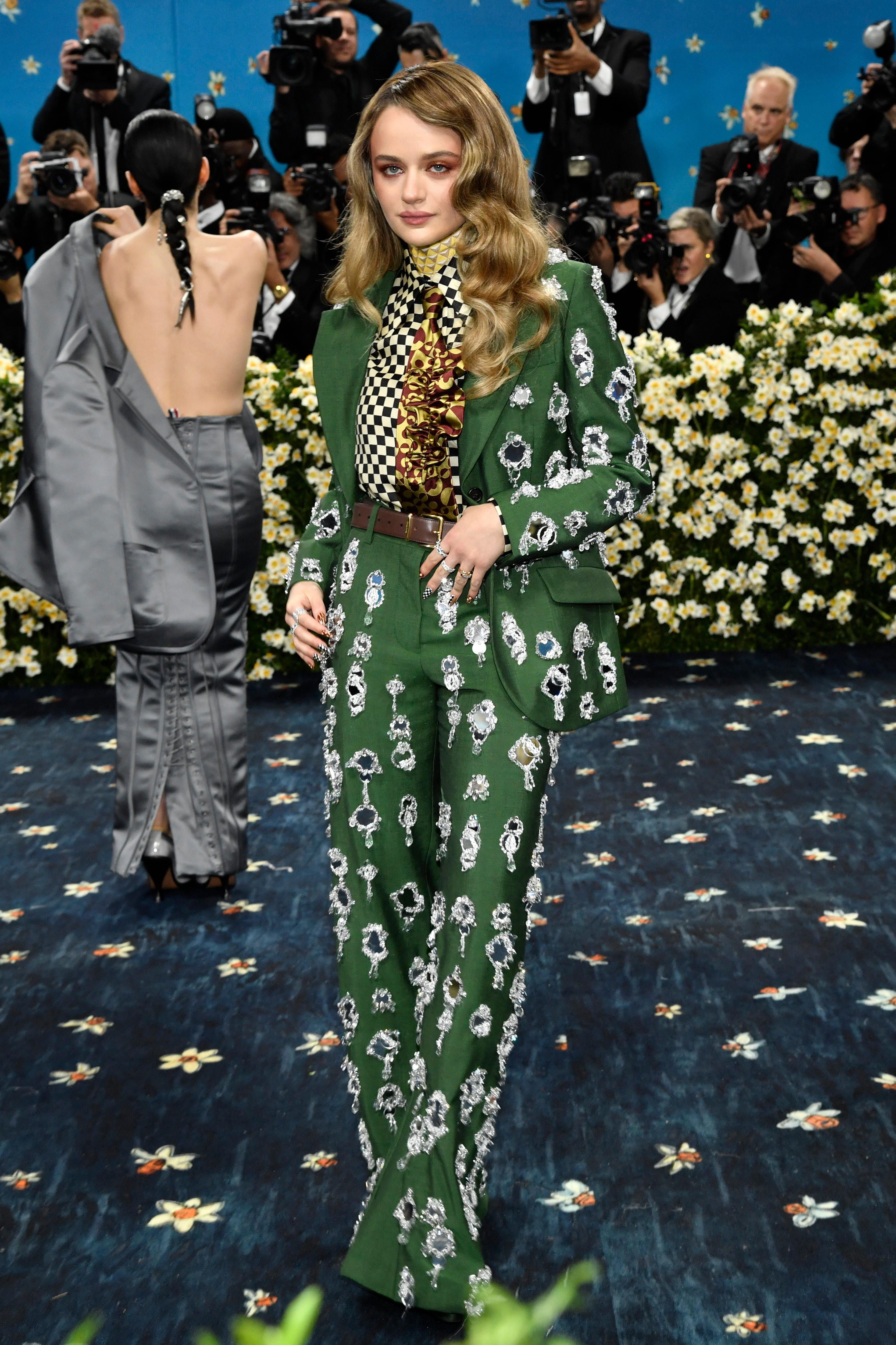 Joey King wearing an emerald green suit with silver bedazzling and a black-and-white checked shirt