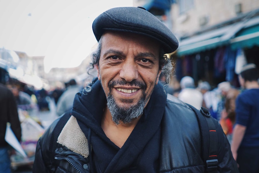 Yekhyeale Hajabi stares at the camera in a busy street in Jerusalem.