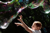 A child plays with soap bubbles.
