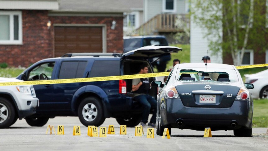 Evidence markers lie on a street at the scene of a police shooting in Moncton.