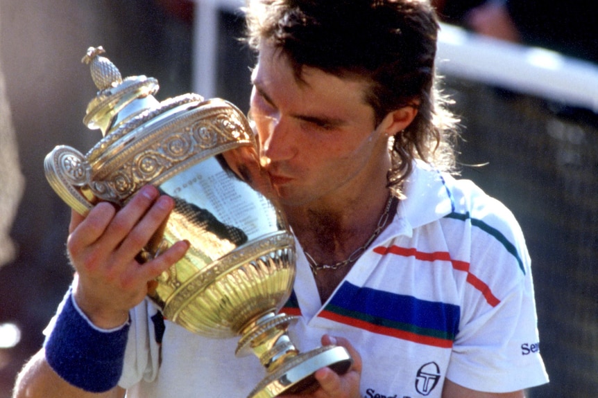 Pat Cash kisses the Wimbledon trophy