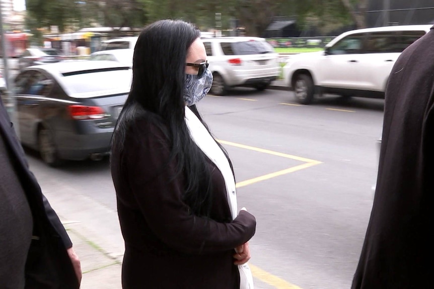 A woman in sunglasses and a mask outside an Adelaide court.
