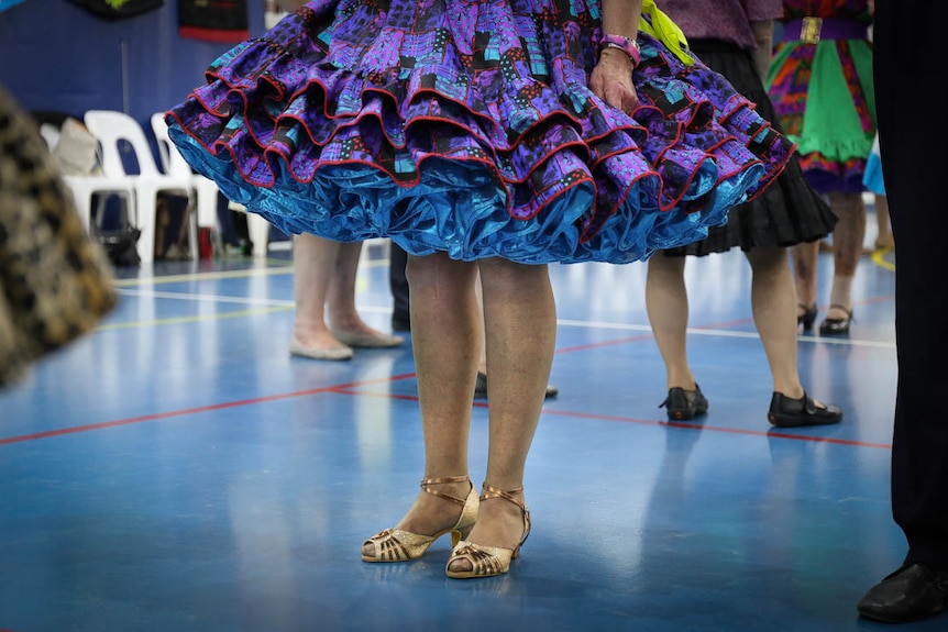 Woman in gold heels and purple skirt