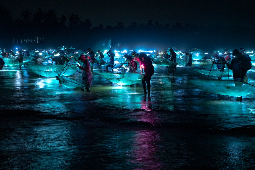 Fisherman gather around at nighttime 