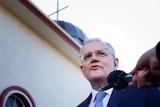 A man stands in front of a church