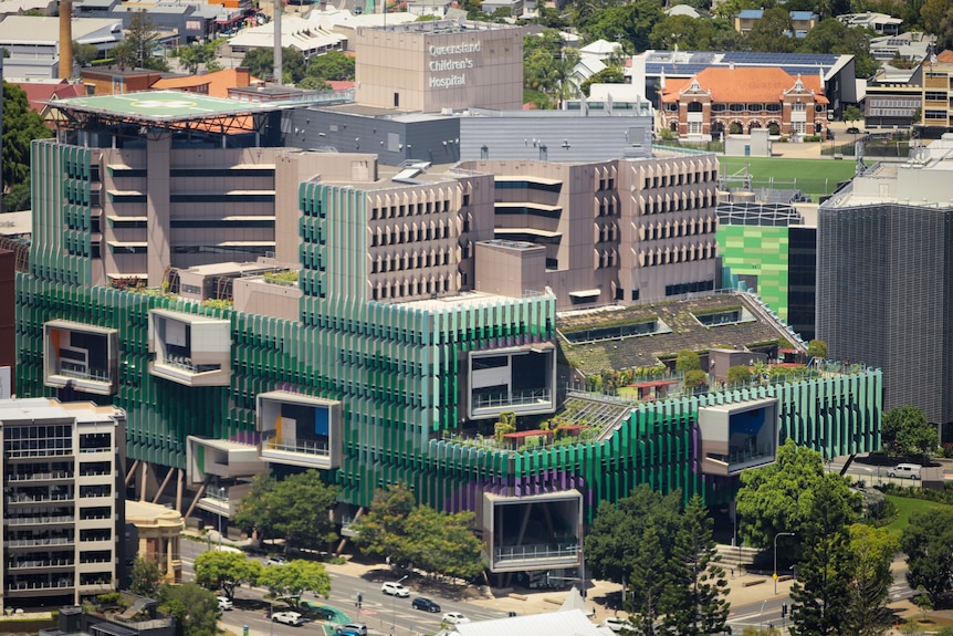 A large multi-storey hospital with green cladding.