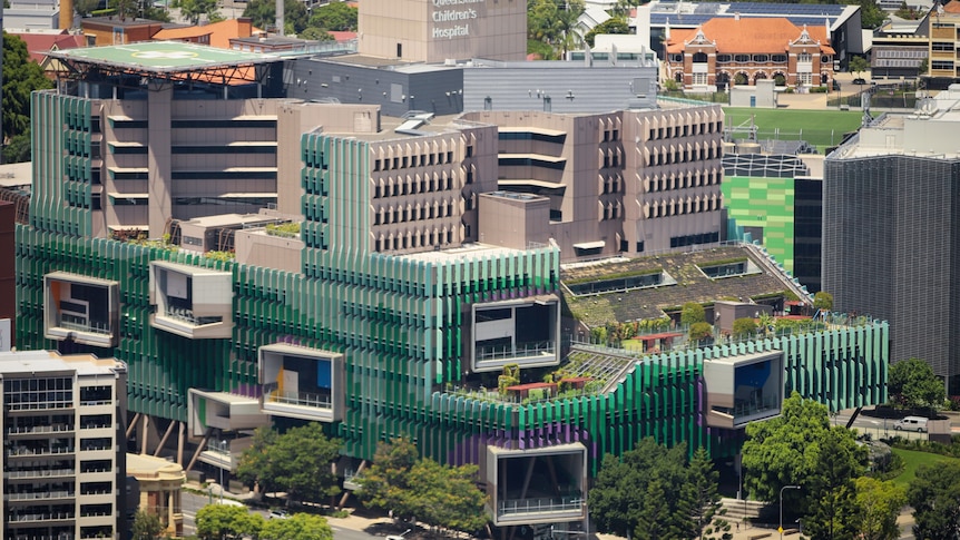 A large multi-storey hospital with green cladding.