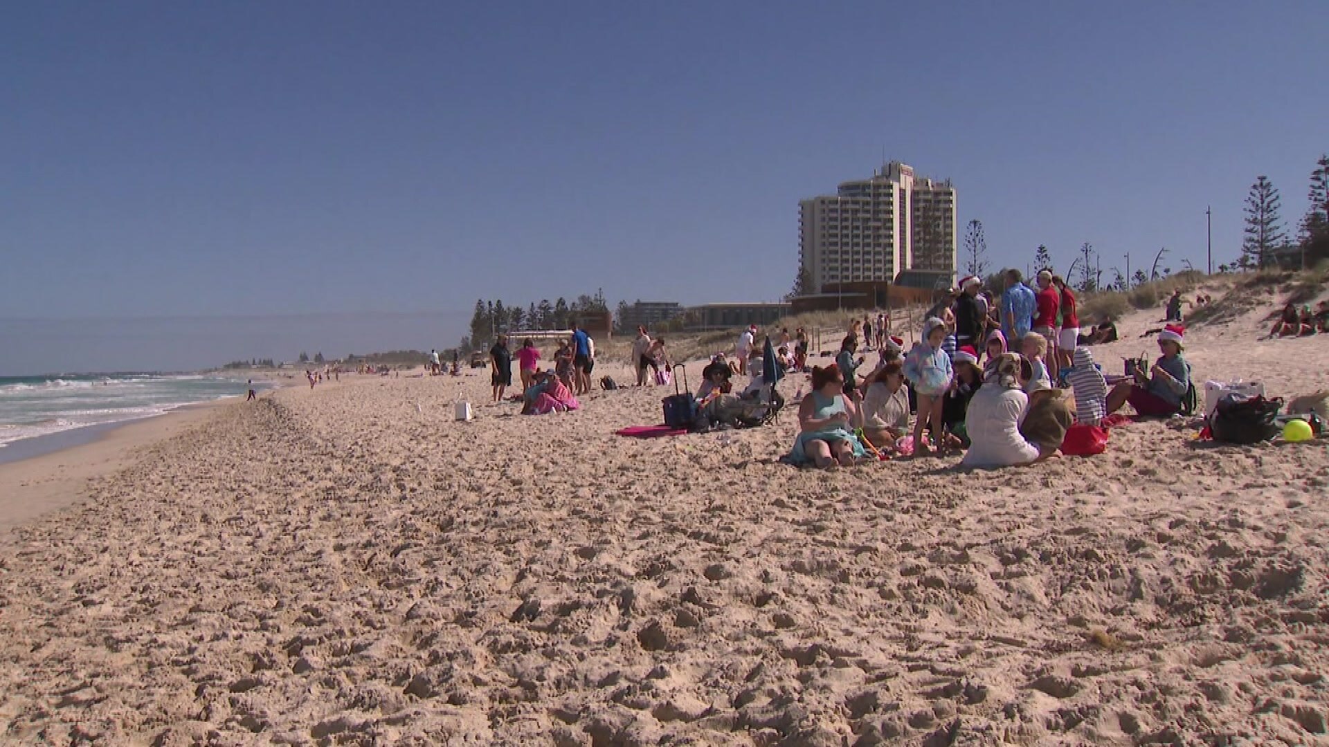 A beach in Western Australia with a large building in the background. 