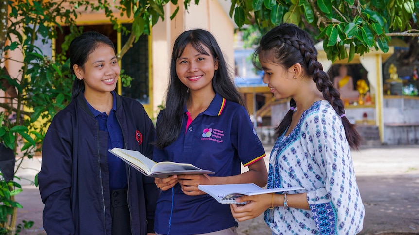 Chatnika Yat holding a book, at Auscam in Cambodia