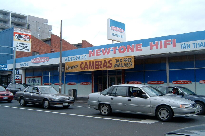 A large shop front with cars parked out the front, and the words 'Newtone Hifi' across the front.