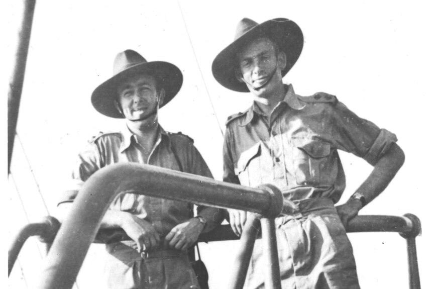 Black-and-white photo of two men in uniform, standing next to each other.