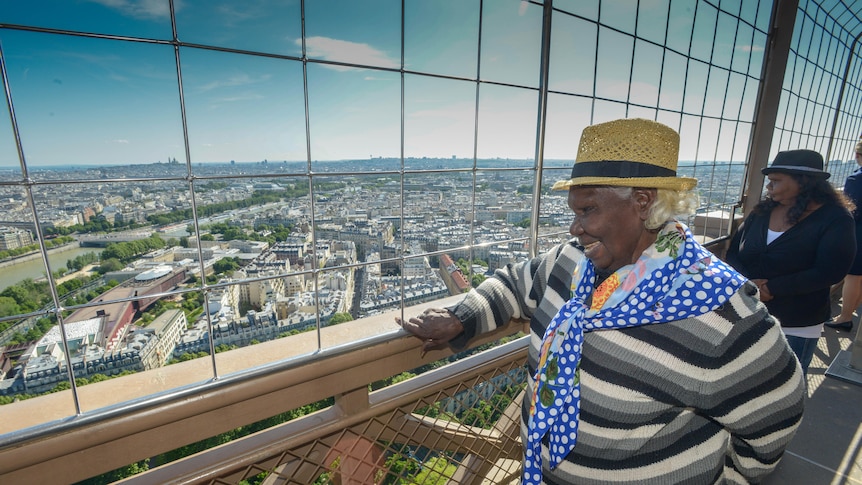 indigenous woman looks over Paris skyline