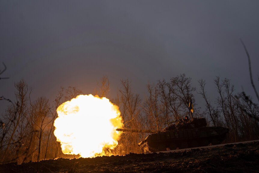 A fire ball shoots from a Ukrainian tank as it fires towards Russian positions.