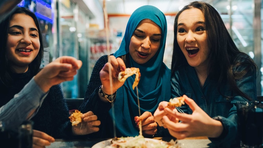 Three young middle eastern women enjoying a meal together