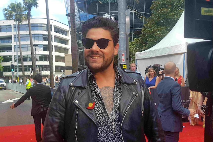 Dan smiling on the red carpet.