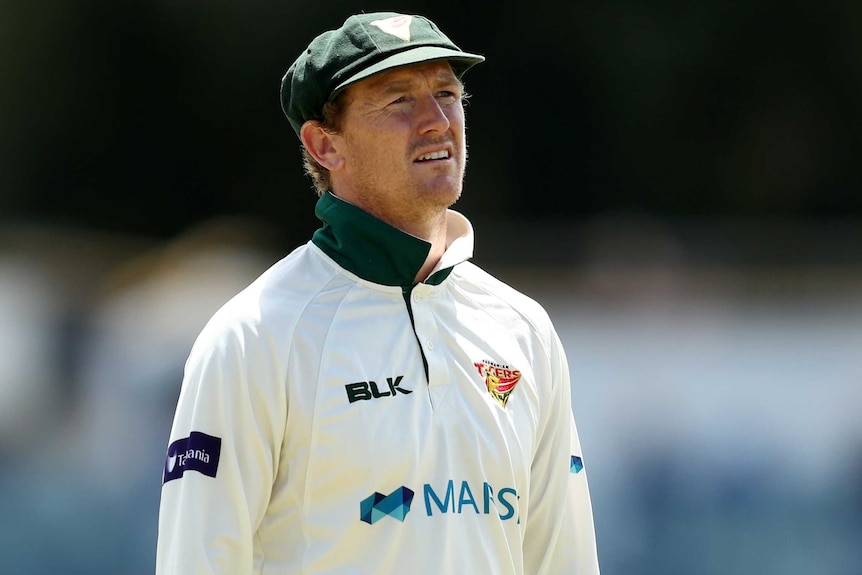 A Tasmanian Sheffield Shield player stands in the field as he looks towards the sky against Western Australia at the WACA.