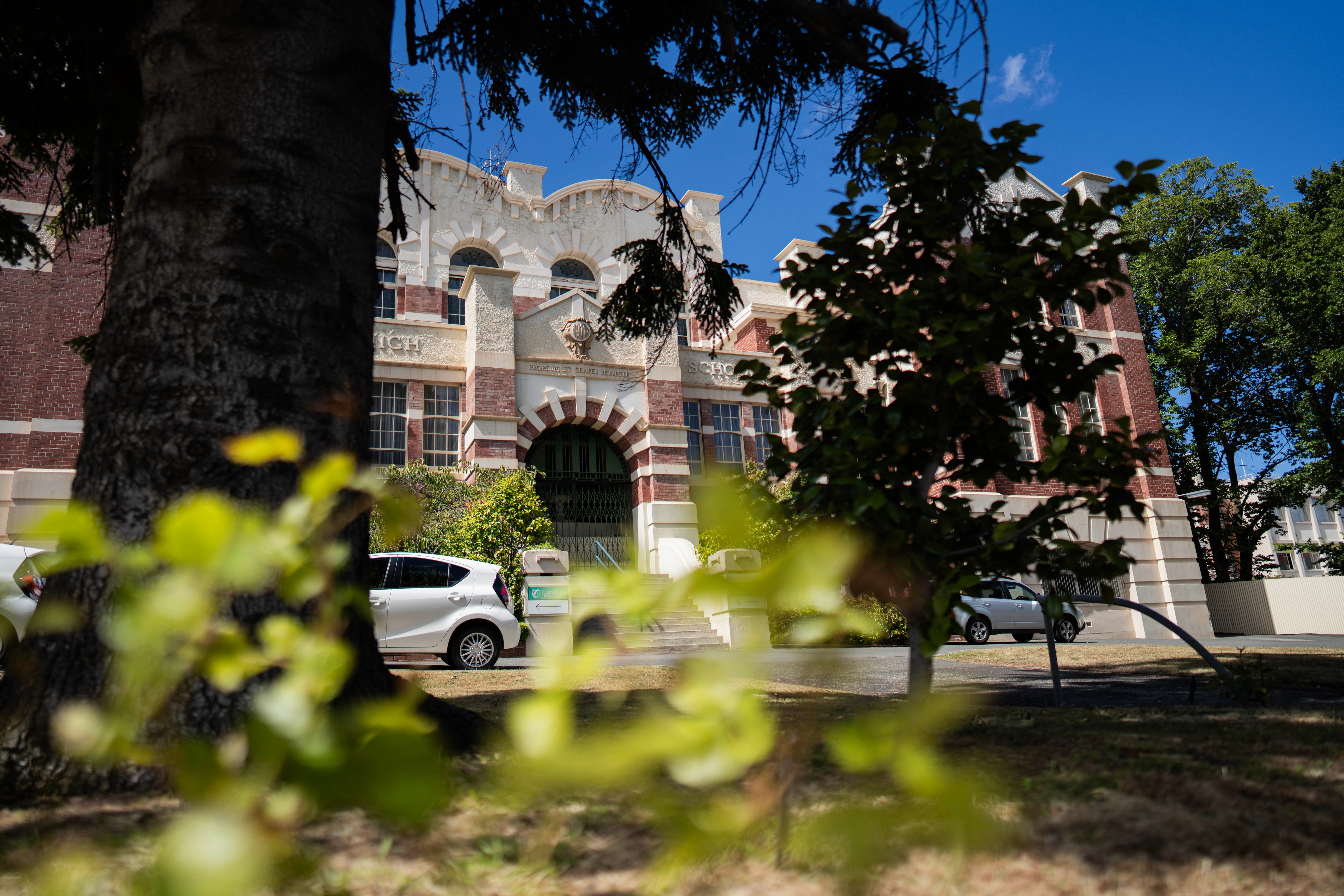 Παλαιό σχολικό κτίριο σε λευκό και καφέ ψαμμίτη.