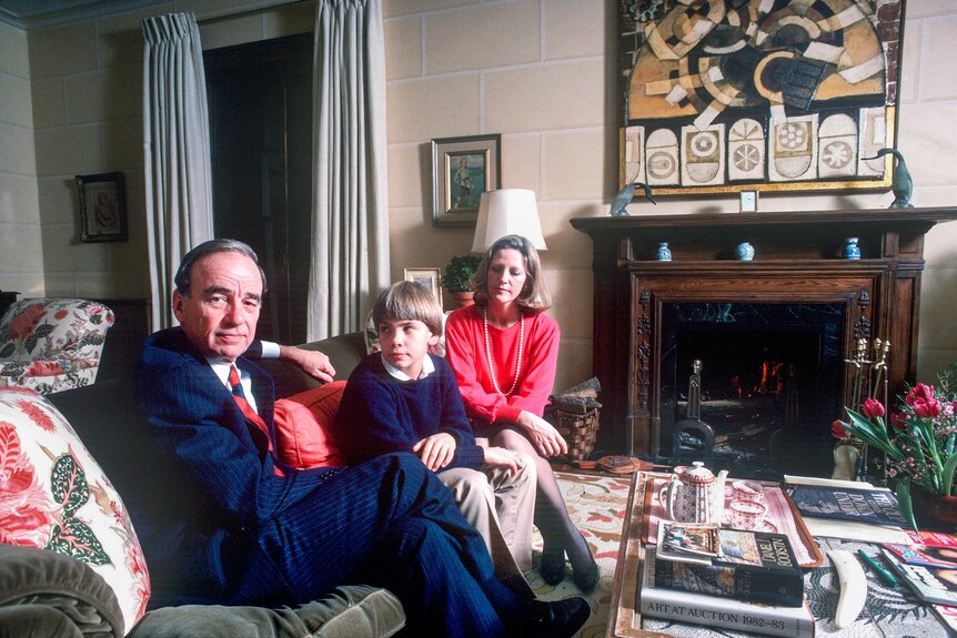Rupert Murdoch sitting on a couch with a young boy and a blonde woman