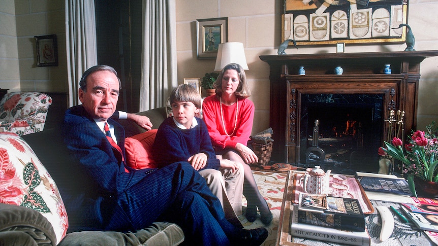 Rupert Murdoch sitting on a couch with a young boy and a blonde woman