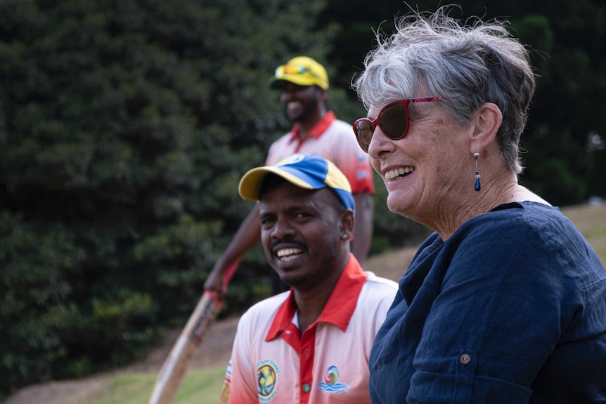 Noeline Nagle smiling, while looking over the game.