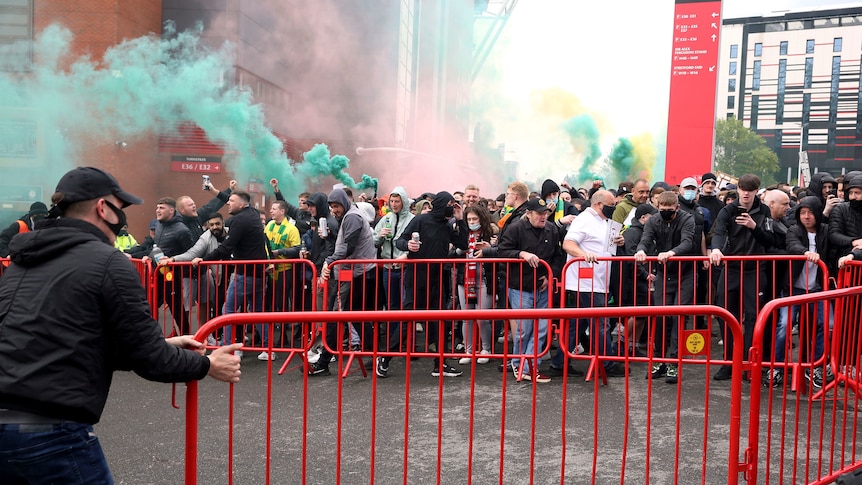 Fans protesting outside Old Trafford stadium with flares