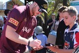 Queensland forward Chris McQueen signs an autograph during the Maroons fan day in Longreach.