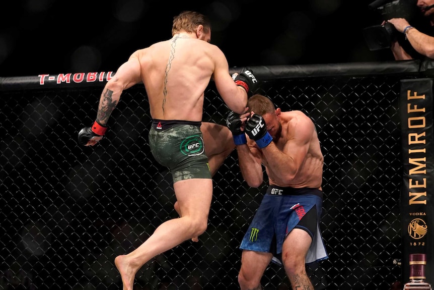 Conor McGregor lands an airborne knee kick to a cowering Cowboy Cerrone in the UFC octagon