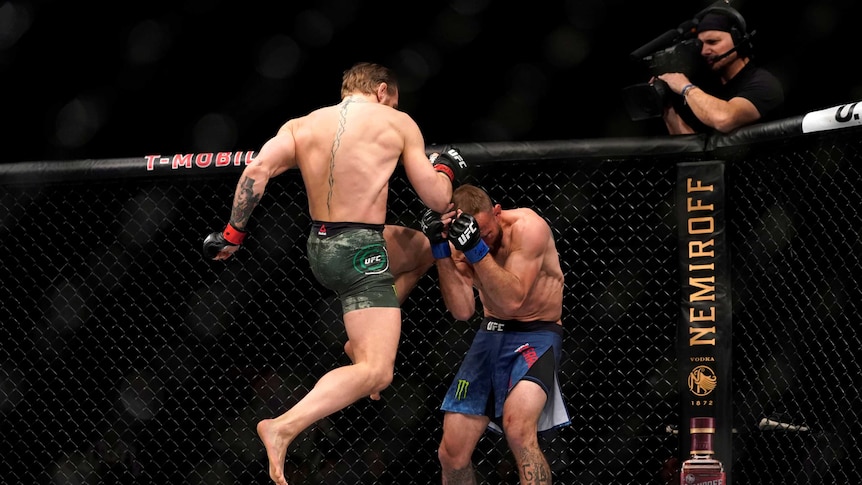 Conor McGregor lands an airborne knee kick to a cowering Cowboy Cerrone in the UFC octagon