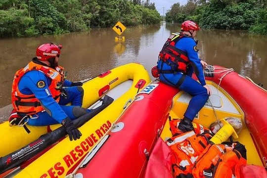 two scuba divers in a raft on a flooded street