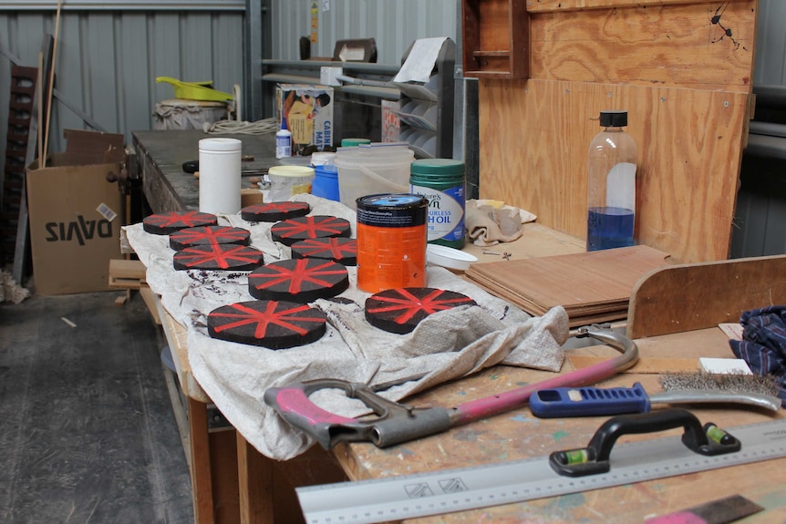 A cluttered workbench inside a woodshed.
