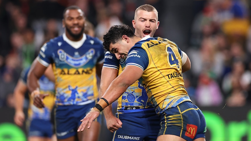 Two Parramatta NRL players embracer as they celebrate a try against South Sydney.