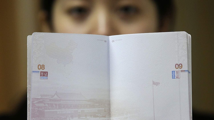 A woman holds a Chinese passport in Wuhan