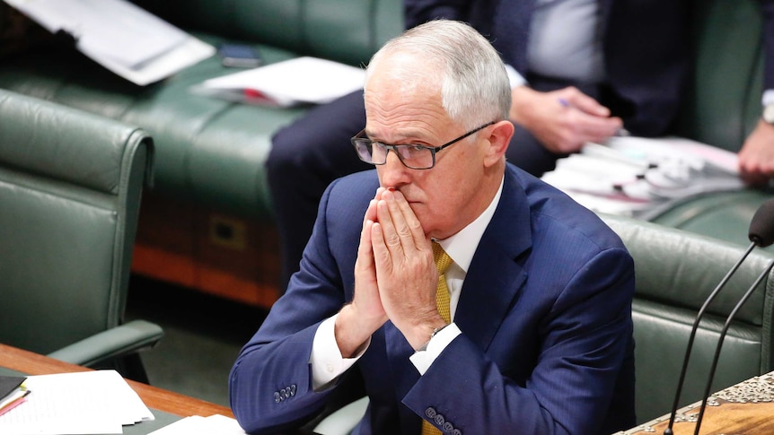 Malcolm Turnbull sits in the House of Reps, with his palms pressed together in front of his pursed lips.