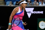 A tennis player appears to be yelling in frustration