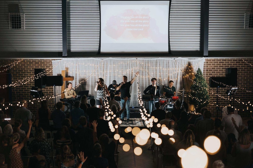 A band sing worship songs at a Baptist service held