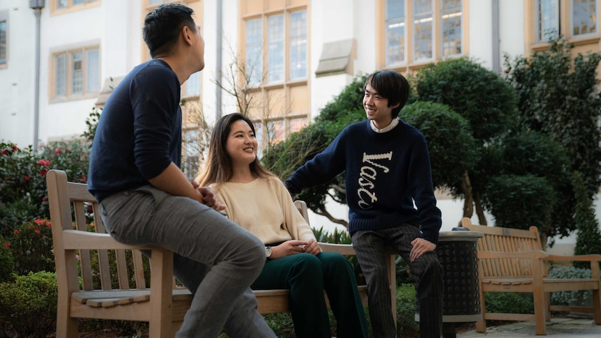Clément Sun and his friend Abbey Shi talk in a courtyard in the University of Sydney.